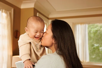 Smiling baby and mother at home